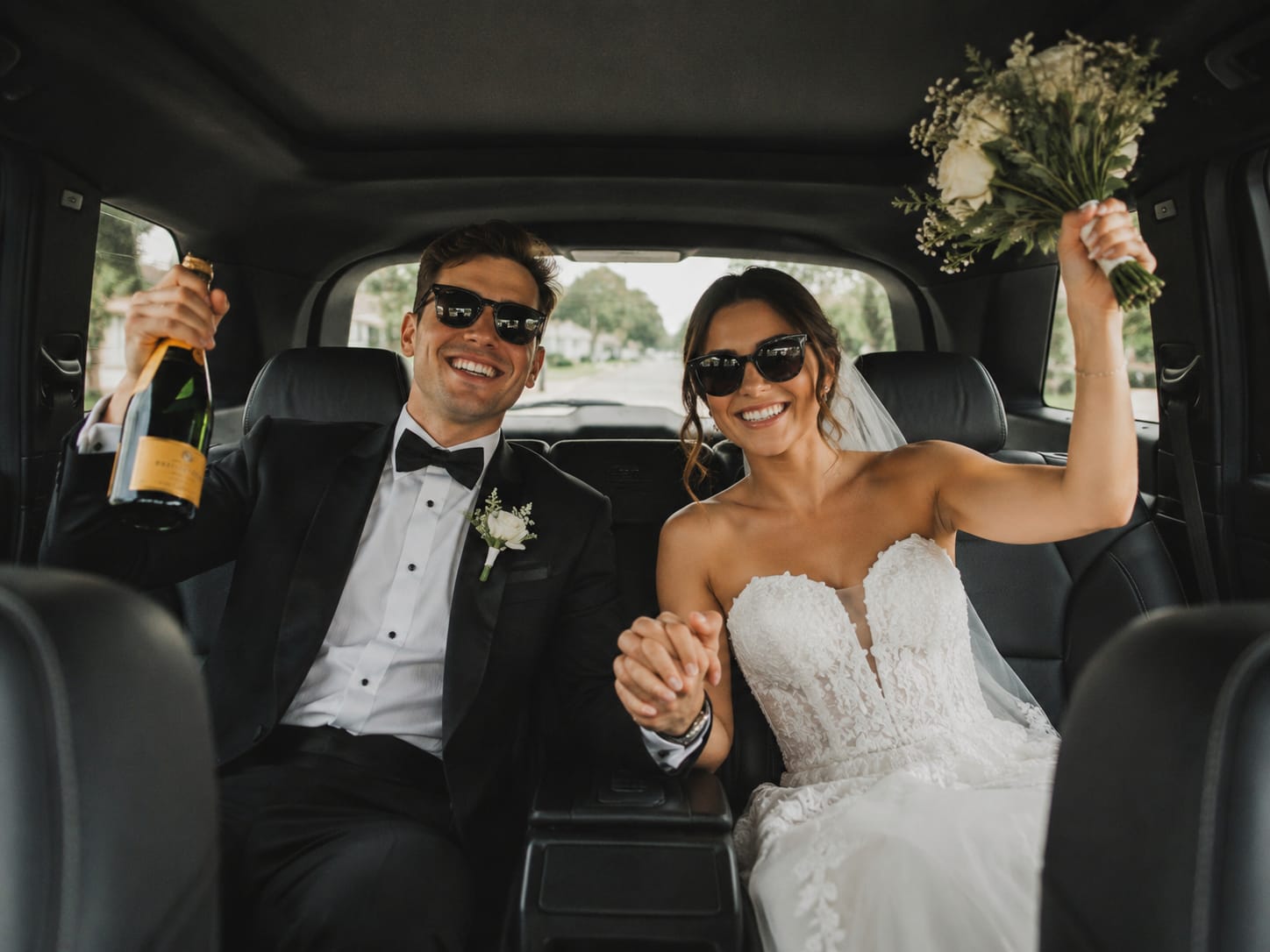 Bride and groom enjoying wedding transportation in a luxury SUV